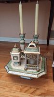 View of the entire Fitz and Floyd set including two candle holders with candles, tealight holder, jar, and octagonal cake plate on the floor.
