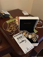 Lot overview: charm bracelet with charms in Pandora box plus chain and bracelets on table