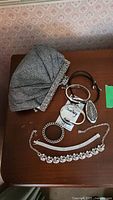 Photo showing grey fabric purse with rhinestone detail and jewelry pieces on table