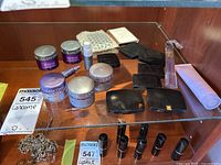 Overview photo showing all Lancôme cosmetics and skincare items displayed on glass shelf, including creams, compacts, lipsticks, and lotion