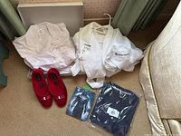 Lot contents showing pale pink pyjama set, red Foamtrends slippers, Hanes polo and T-shirt in packaging, and the robe