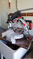 Full side view of Craftsman table saw on workbench, showing dust collection bag and saw blade.