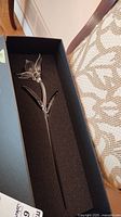 Full view of the Waterford crystal lily flower in its black presentation box, showing flower, stem, and leaves.
