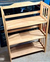 Full view of the 3-shelf folding wooden bookcase showcasing the light wood finish and three shelves with slatted side supports.