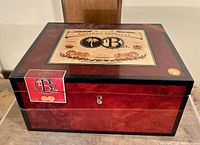 Closed humidor showing exterior finish, lid label and keyhole