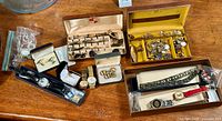 Overview of the lot showing cufflinks displayed in boxes, two wristwatches in their boxes, and additional men's jewelry accessories.