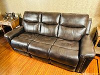 Full front view of the brown leather reclining sofa