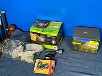 Overview of all lighting items included in the lot: solar string lights box, boxed motion LED floodlight, sealed bulbs, and headlamp.