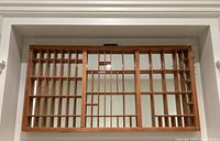 Full front view of the wooden printers drawer mirror hung on a wall, showing all compartments and mirrored backing