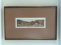 Full view of framed rural village scene print mounted with warm brown mat and multi-tone wooden frame