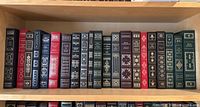 Full shelf view showing 21 leather bound Franklin Library classic novels in various colors with gold foil spine decoration
