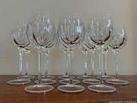 Front view of 13 clear crystal wine glasses arranged in rows