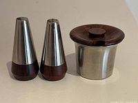 Photo showing the full set: two conical salt and pepper shakers with rosewood bases and stainless steel tops next to a stainless steel mustard pot with rosewood lid.