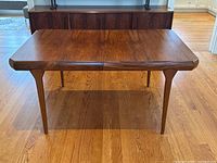 Front three-quarter view of rosewood dining table without leaves