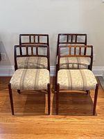 Four chairs front view on hardwood floor against wall