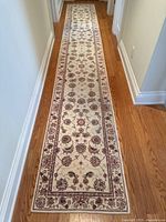 Full-length view of runner on hardwood floor showing overall pattern and border.