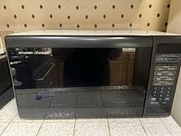 Front view of black Sharp Carousel microwave with control panel on right