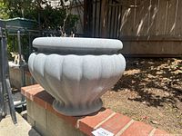 Front angled view showing the shape and size of the faux cement planter with lotus pod style scalloped sides and wide rim.