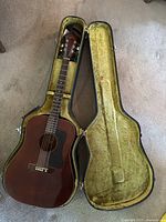 Full view of Guild acoustic guitar inside open hardshell case