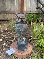Front view of solar owl decoy showing amber eyes and textured feathers.