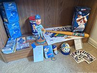 Photo showing the full collection including the Steve Garvey bobblehead, Dodgers helmet radios, baseball cards, a mini bat, Dodgers pennant, a baseball with holder, a fan bobblehead, and ticket stubs.