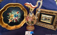 Photo showing all three items including the wood tray with painted flowers, ceramic Deruta pitcher, and framed artwork.