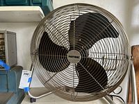 Front view of the Patton metal floor fan showing the protective metal grill and four black blades with the Patton logo at the center.