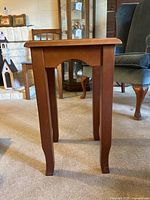 Front view of tiny tea table showing rectangular top and four legs with slight curve at bottom