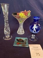 Image showing all four vases and the small fused art glass dish together on a dark blue background with faux grapes inside one vase.