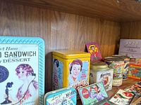 Photo showing a collection of vintage tins and collectible items including Oreo, Toll House, Hershey's, and Coca-Cola.