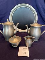 Full set shot showing coffee pot, tea pot, sugar bowl, creamer, and tray against dark backdrop.
