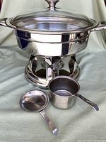 Full assembled view of chafing dish with glass lid and accessories arranged in front