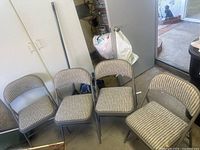 Four Sudden Comfort folding chairs arranged together showing grey striped cushioned seats and backs.