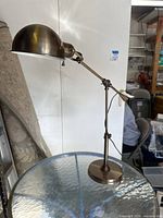 Full view of the replica industrial desk lamp showing adjustable arm and domed hood in antique brushed bronze finish.