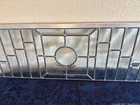 Close-up showing the detailed geometric design with a circular center of the stained glass panel.