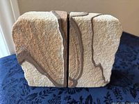 Front view of the two sandstone bookends placed vertically next to each other, showing organic stone texture and natural color variations.