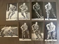 Photo showing all 8 black and white Montreal Canadiens postcards laid out in two rows on a flat surface, all featuring autographed hockey players from the 1960s.