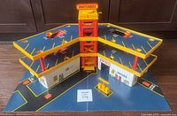 Front angled view of the Matchbox Super Garage showing the multiple levels, ramps, and central elevator tower.