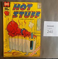Front cover of the comic book showing the main character Hot Stuff The Little Devil on a radiator with a yellow background.