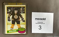 Front side of 1980-81 OPC Hockey #140 Ray Bourque rookie card showing player in Boston Bruins uniform labeled 'ROOKIE CARD'.