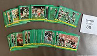 Front side of 1984 Fleer NFL trading cards showing player action shots with green borders and yellow team labels spread out face up.