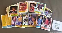 Photo showing a large pile of 1986-87 O-Pee-Chee hockey cards spread out with several cards face-up featuring various players.