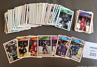 View of a large stack of hockey cards from 1988-89 showing several cards including Dave Taylor and Gary Suter All-Star card.