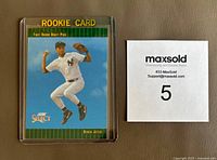 Front view of the 1993 Score Select Derek Jeter Rookie Card #360 in plastic protective case beside a MaxSold card with number 5