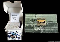 Photo showing the complete set of Skybox 1995 NFL football cards stacked inside the empty Skybox wax box with the lid open, displaying the box design featuring team names in green and gold.