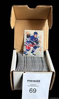 Box holding the complete set of 120 hockey cards with one card shown upright on top.