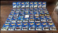Overview photo showing 40 Hot Wheels cars laid out in sealed original packaging with blue backing card