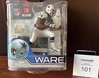 Front view of sealed Demarcus Ware NFL figurine in original packaging showing player in dynamic pose, helmet with Dallas Cowboys star, number 94.