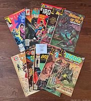 Photo showing all 10 comics arranged fan-like on floor: Willow, Alias Blastpoint, Iron Jaw, two issues of Tragg the Sky Gods, two issues of Ripley's Believe It or Not, House of Yang, Outlaws of the West, Beyond the Grave