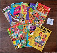 Full lot of 11 comic books arranged on wooden floor, showing all front covers